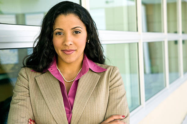Multi-ethnic businesswoman with arms crossed Portrait of young Hispanic businesswoman standing in front of her workplace. She is ethnically ambiguous and can be of Mediterranean, Arabic, Indian or Middle Eastern descent. She is also multi-racial. puerto rican women stock pictures, royalty-free photos & images