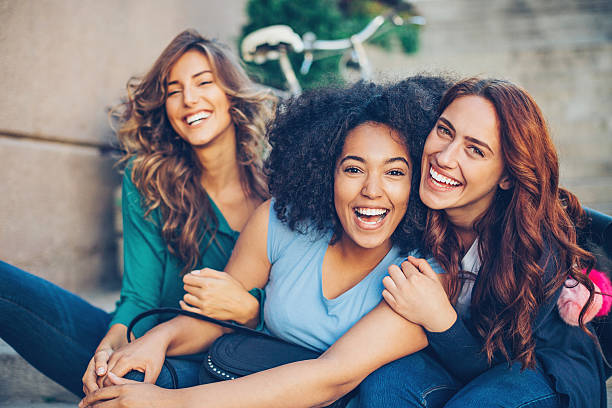 Multi-ethnic group of girls laughing Small multi-ethnic group of beautiful young women laughing outdoors girlfriend stock pictures, royalty-free photos & images