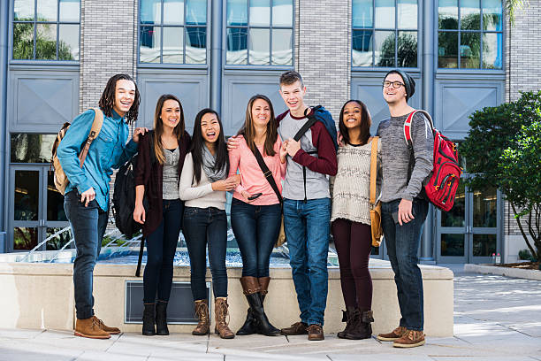 Multi-ethnic group of students A multiracial group of high school or university student standing in a row outside a building. Schools buildings stock pictures, royalty-free photos & images