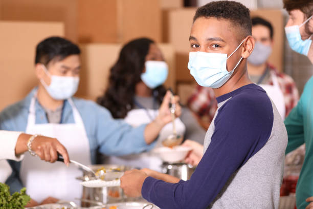 Multi-ethnic group of volunteers work at soup kitchen. stock photo