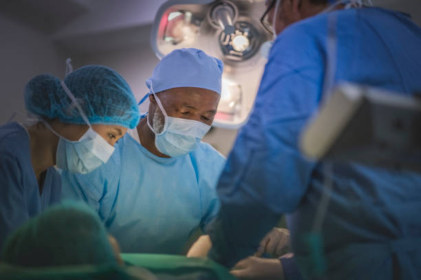 Multi-ethnic surgeons operating in emergency room stock photo