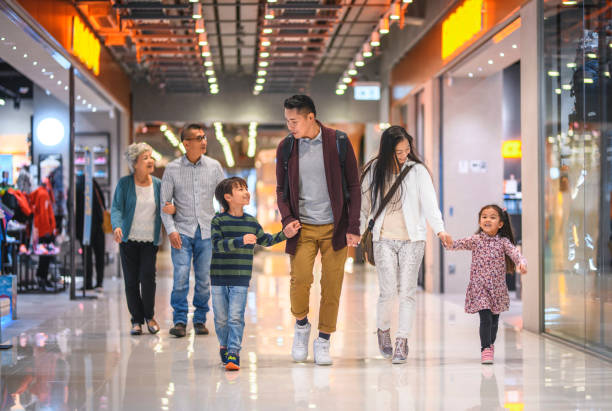 Multi-Generation Chinese Family Enjoying Evening at the Mall Young Chinese family and senior couple window shopping at Harbour City Shopping Centre in Hong Kong. shopping stock pictures, royalty-free photos & images