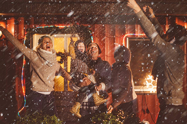 Multi-generation family enjoying a snowy winter day Portrait of a cute multi-generation family in the backyard greeting the first snow for the winter season snow party stock pictures, royalty-free photos & images