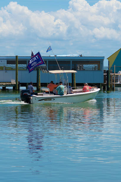Multi-generational Family Flies "Trump 2020" Flag Onboard a May-Craft Fishing Boat , Tangier Island, Virginia Tangier Island, Virginia / USA - June 21, 2020: A multi-generational family in a May-Craft center console boat flying a “Trump 2020” flag enjoy a day on the water in this popular tourist destination in the Chesapeake Bay. tangier island stock pictures, royalty-free photos & images