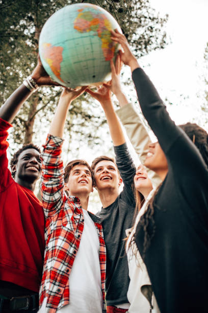 multiracial friends with globe at the park stock photo