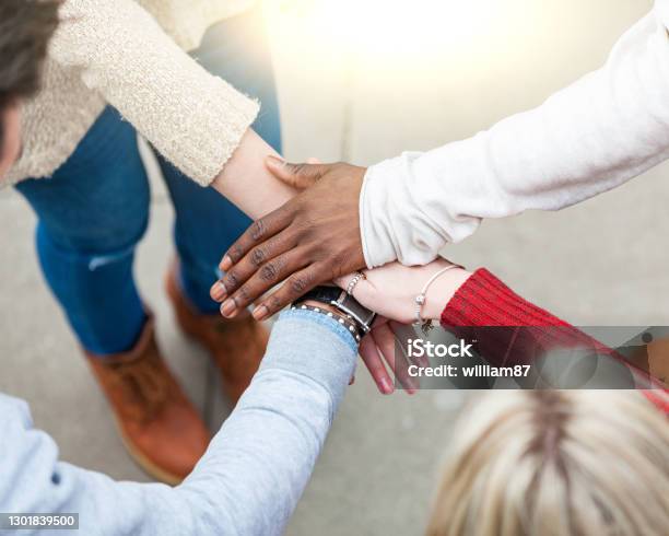 Multiracial hands in a stack, friends in a teamwork effort - Black and white hands together, close up view of multietnihc models in London helping each other