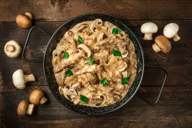 Mushroom beef stroganoff in pan with copy space Mushroom beef stroganoff, with cremini and champignons, in a frying pan, shot from above on a dark rustic texture with a place for text casserole dish stock pictures, royalty-free photos & images