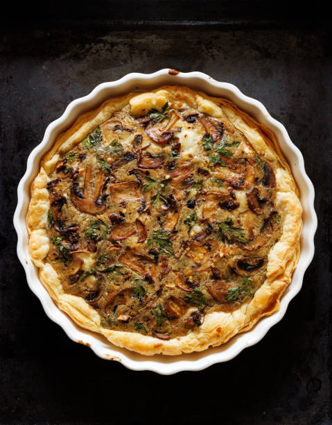 Mushroom quiche, tart with herbs and spices on a dark background stock photo