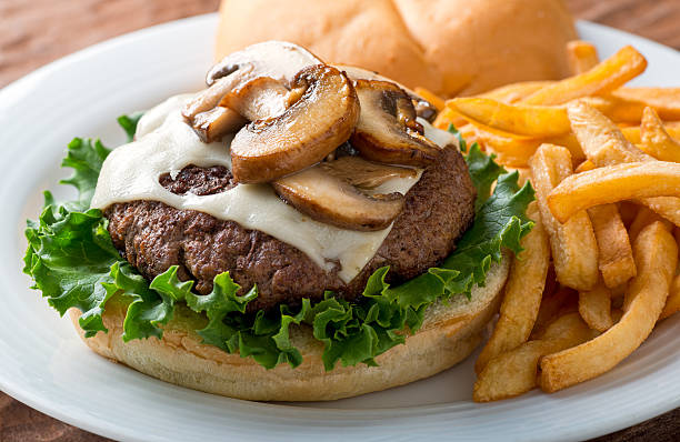 Mushroom Swiss Burger A delicious hamburger topped with swiss cheese and fried mushrooms on a kaiser. swiss culture stock pictures, royalty-free photos & images