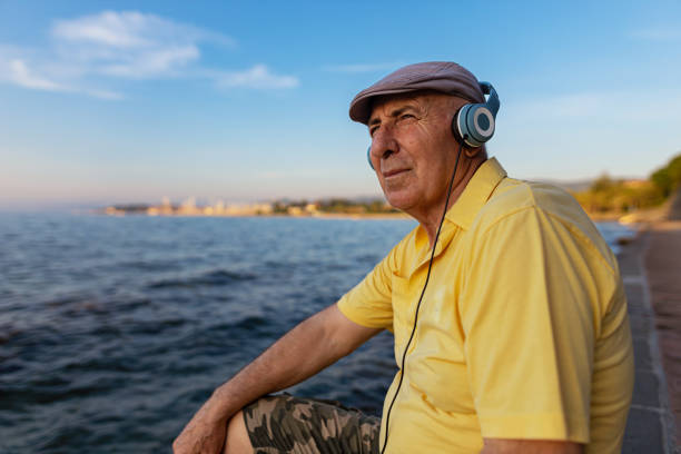music is therapy for the soul - senior listening music beach bildbanksfoton och bilder