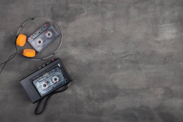 Music listening concept. Vintage cassette tape, audio player and headphones close-up on grey concrete background, top view. stock photo