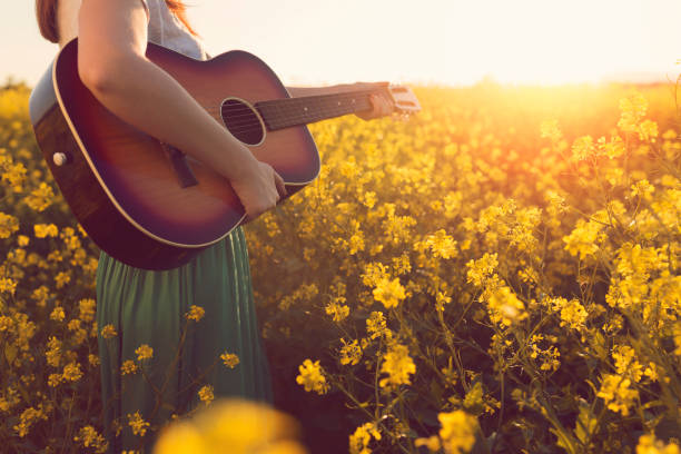 Music of the summer magic Close-up of an unrecognizable female playing acoustic guitar in the nature. country and western music stock pictures, royalty-free photos & images