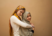 Friendship of the religions concept: muslim and christian girl together