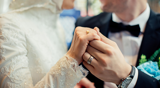 Muslim Couple Holding Hands Together With Wedding Rings Muslim Couple Holding Hands Together With Wedding Rings