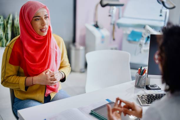 A Muslim patient reviews the results of medical tests with her female gynecologist stock photo