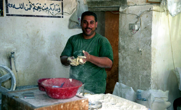 Muslim people Iraq, Baghdad - 2 may 2005 A man prepares food from dough old arab man stock pictures, royalty-free photos & images