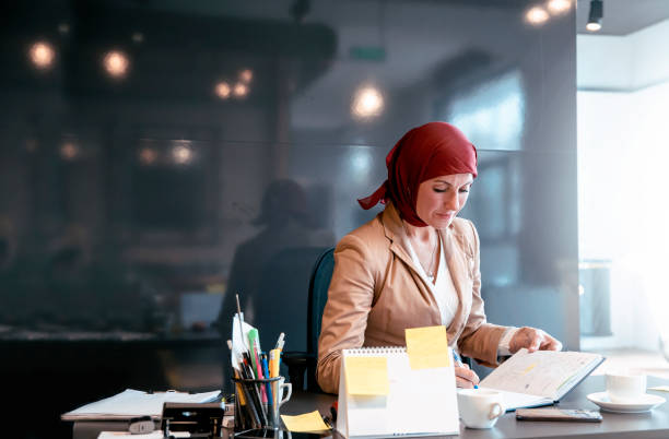Muslim Woman doing paperwork at the desk stock photo