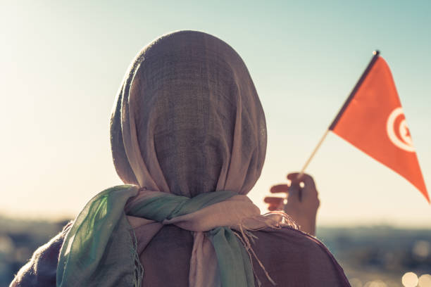 Muslim woman in scarf with Tunisia flag of at sunset.Concept Muslim woman in scarf with Tunisia flag of at sunset.Concept tunisia woman stock pictures, royalty-free photos & images