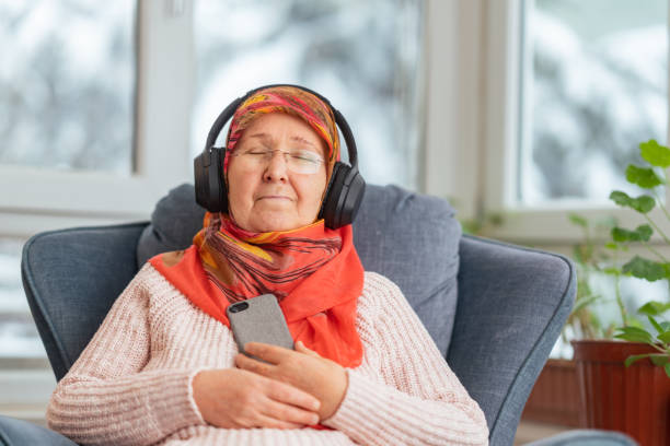 Muslim woman using smart phone and listening to music or podcast stock photo