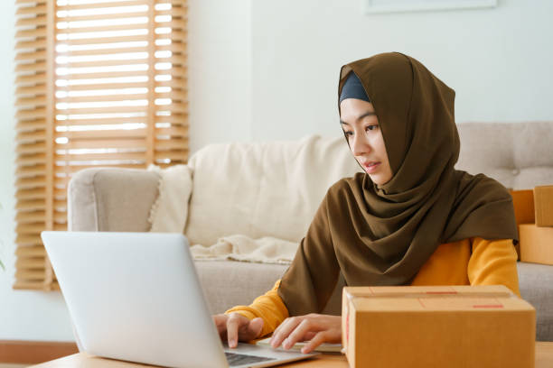 Muslim young women wear hijab using typing and checking order the customer address on the computer laptop at home morning. Concept business small and shop online Muslim young women wear hijab using typing and checking order the customer address on the computer laptop at home morning. Concept business small and shop online indonesian girl stock pictures, royalty-free photos & images
