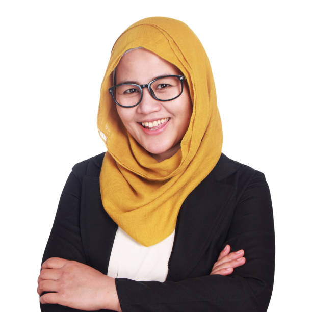 Muslimah Businesswoman Smiling Friendly Asian muslimah businesswoman wearing glasses and suit smiling friendly with arms crossed. Isolated on white indonesian woman stock pictures, royalty-free photos & images