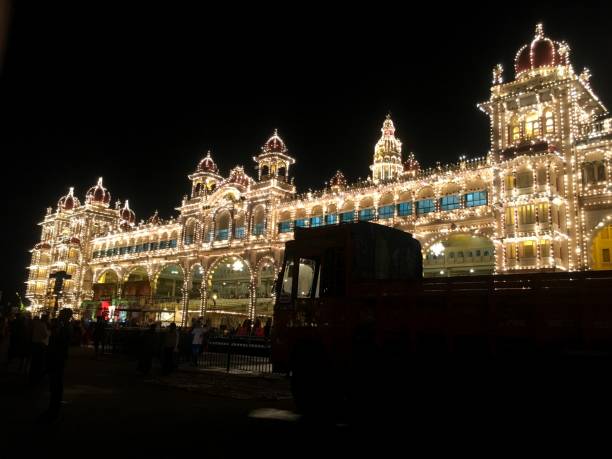 Mysore palace on eve of Dussehra The illuminated Mysore Palace is seen in the background of a truck parked nearby during the Dussehra festival on October 17, 2018, in Karnataka, India. mysore stock pictures, royalty-free photos & images