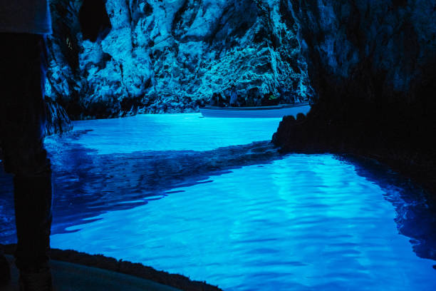 Mysterious blue cave, Modra Spilja, Bisevo, Croatia People visiting spectacular blue cave in boat, Modra Spilja, Bisevo, Croatia grotto cave stock pictures, royalty-free photos & images