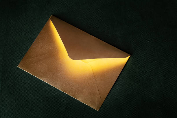 Mysterious golden letter with magic light from the inside Fairytale mail. Mysterious letter with magic light lying on velvet background. love mail. valentines day concept envelope photos stock pictures, royalty-free photos & images