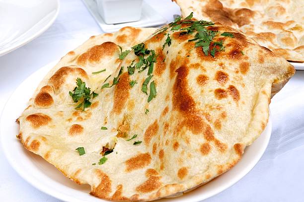 Naan bread Indian naan bread served on a plate - resubmit with improved lighting naan bread stock pictures, royalty-free photos & images