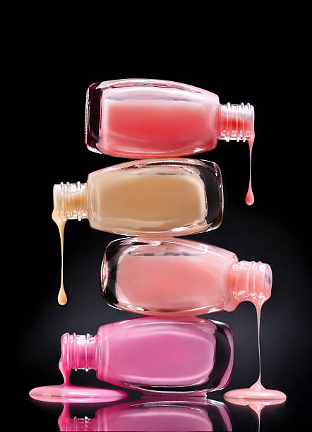 nail polish dripping from open bottles - nail polish bottle close up stockfoto's en -beelden
