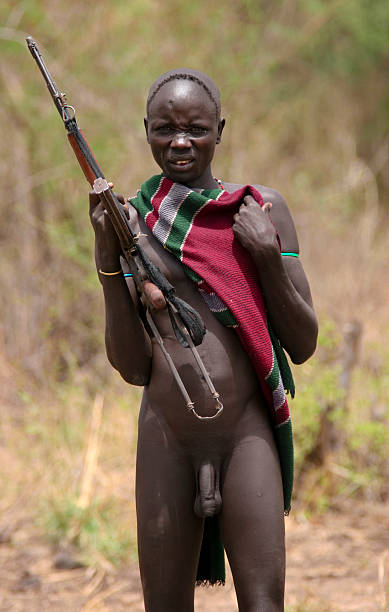 Naked Mursi Man With Rifle stock photo