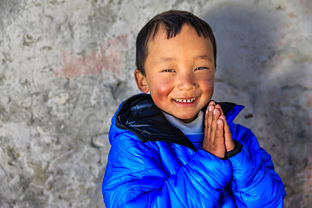 Namaste! - portrait of young Sherpa boy in Everest Region Sherpa are an ethnic group from Khumbu - the most mountainous region of Nepal, high in the Himalayas. Many of them live inside Mount Everest National Park - the highest national park in the world, with the entire park located above 3,000 m ( 9,700 ft). This park includes three peaks higher than 8,000 m, including Mt Everest. Therefore, most of the park area is very rugged and steep, with its terrain cut by deep rivers and glaciers. Unlike other parks in the plain areas, this park can be divided into four climate zones because of the rising altitude. tibetan ethnicity stock pictures, royalty-free photos & images