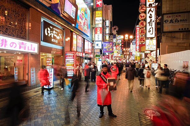 Namba entertainment district, Osaka, Japan "Osaka, Japan - March 18, 2012: Namba entertainment district. Many people can be seen in the pedestrian zone outside shops and restaurants. Touts can be seen in orange soliciting customers for restaurants and bars." mcdonalds japan stock pictures, royalty-free photos & images