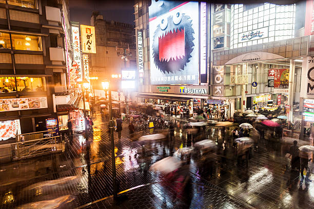 Namba entertainment district, Osaka, Japan "Osaka, Japan - March 18, 2012: Namba entertainment district. Many people can be seen in the pedestrian zone outside shops and restaurants - many are carrying umbrellas for the rain." mcdonalds japan stock pictures, royalty-free photos & images