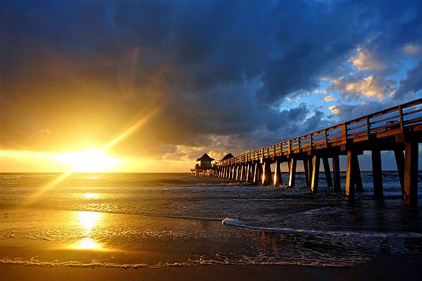 Naples Pier Sunset A popular tourist attraction place in Naples, Florida. Picture taken in 2016. naples florida beach photos stock pictures, royalty-free photos & images