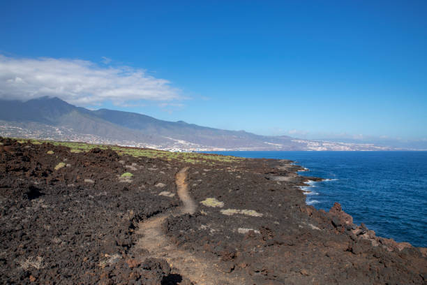 Narrow footpath through the arid badlands of lava and volcanic rocks known as Malpais de Guimar, Tenerife, Spain stock photo
