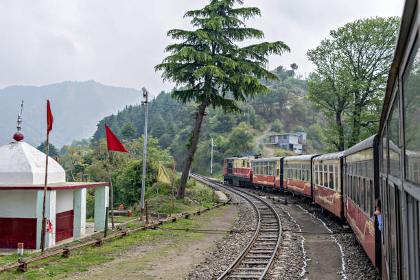 Narrow gauge Shivalik Deluxe express train on curve while departing Shoghi. Shoghi,Himachal Pradesh, India: April 14th, 2015- Narrow gauge Shivalik Deluxe express train on curve while departing Shoghi. shimla stock pictures, royalty-free photos & images