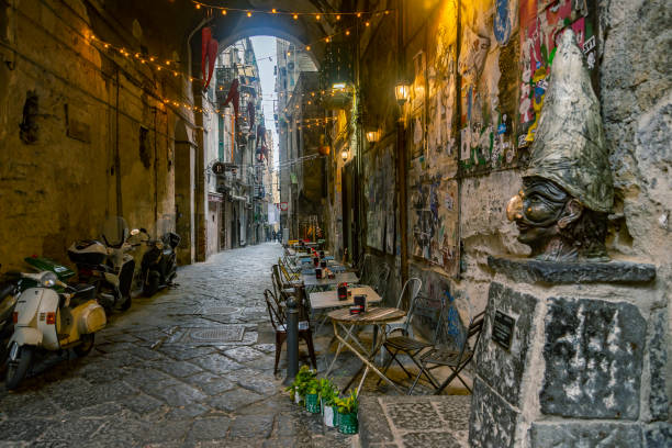 narrow streets of the historical center, the traditional mask with face of Pulcinella in the old town of Naples, Campania, Italy stock photo