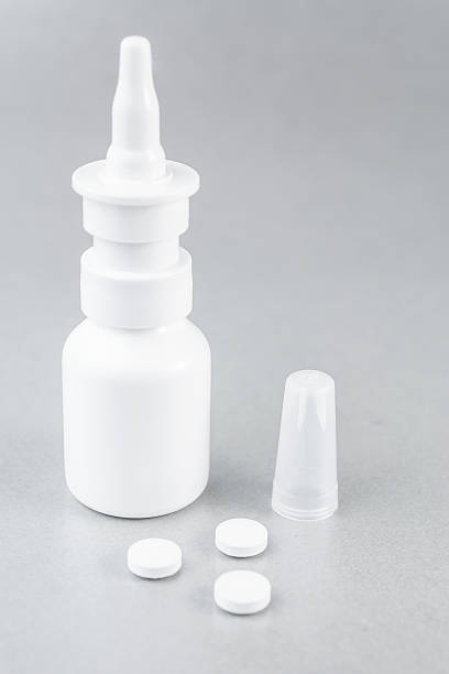 Nasal spray and white pills stock photo