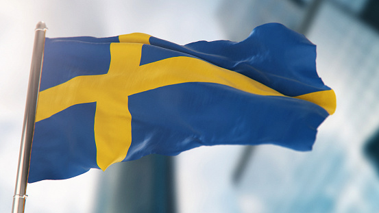 national-flag-of-sweden-against-defocused-city-buildings-picture-id1295643750