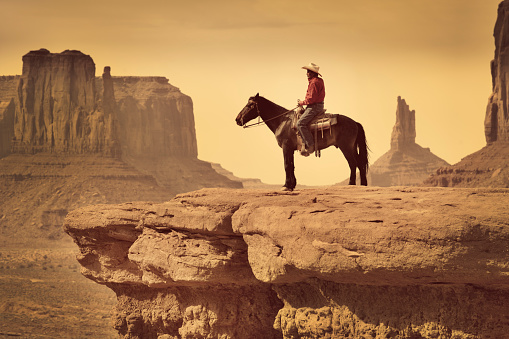 Subject: A native American Indian cowboy on a horse over a cliff looking into the distance.