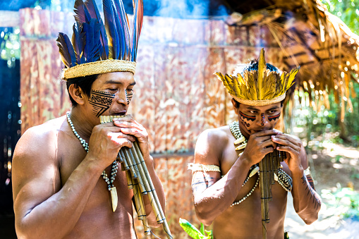 Native Brazilian Guys Playing Wooden Flute At An 