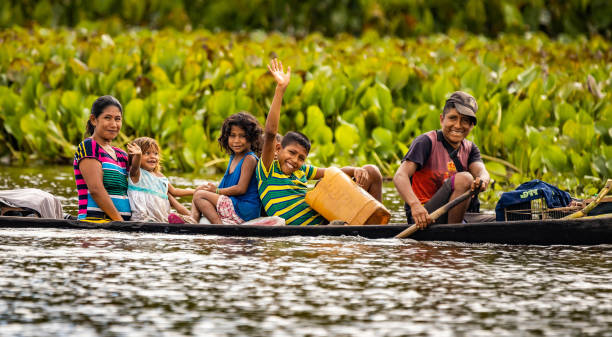 Native Orinoco tribe people in traditional boat in Venezuela stock photo