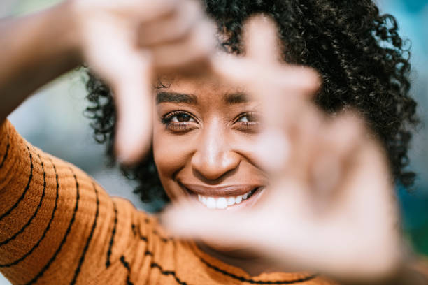 Natural Beauty Portrait With Womans Finger Frame A beautiful African American woman smiles while framing her face with her fingers.  Shot in Los Angeles, California. determination photos stock pictures, royalty-free photos & images