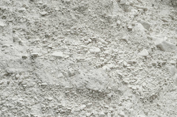Natural chalk mineral background. Small smooth calcite stones are mixed with chalk clay. Calcium in nature. Natural white chalk texture Natural chalk mineral background. Calcite Source. white carbonate sedimentary rock, fine-grained, weakly cemented, soft and crumbly chalk rock stock pictures, royalty-free photos & images