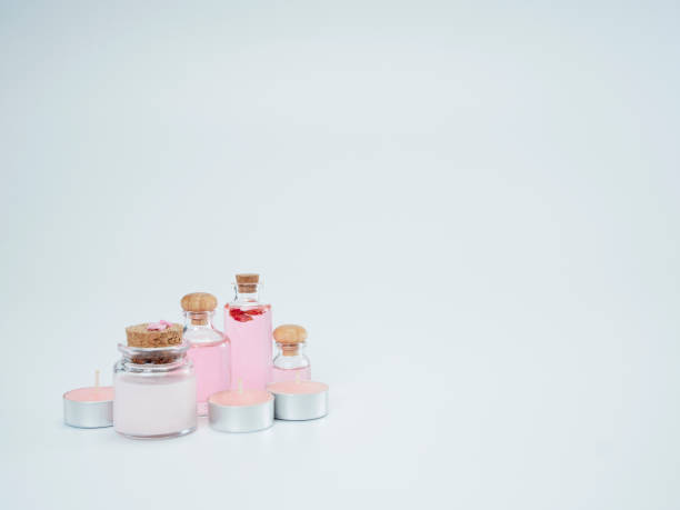 cosmétique naturel avec l'huile de rose et le pot-pourri parfumé de bougie sur le fond blanc. - parfum photo photos et images de collection