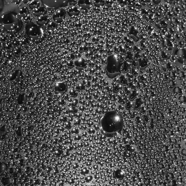 Natural dark silvery black water dew drops texture macro background, vertical textured wet vapour bubble splashes pattern copy space, silver glossy drop detail, large detailed droplet closeup, gentle droplets bokeh stock photo