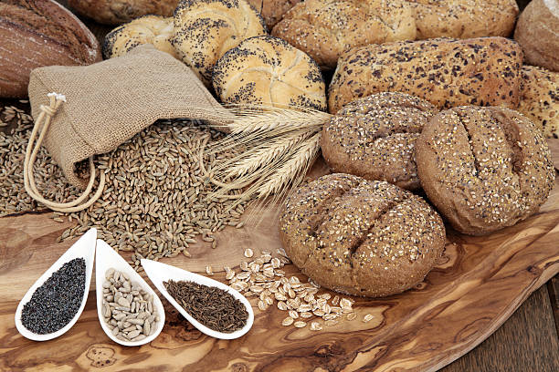 Natural Goodness Seeded bread roll selection with wheat sheaths, rye grain in a hessian sack with chia, sunflower and caraway seed on an olive wood board. 7 grain bread photos stock pictures, royalty-free photos & images