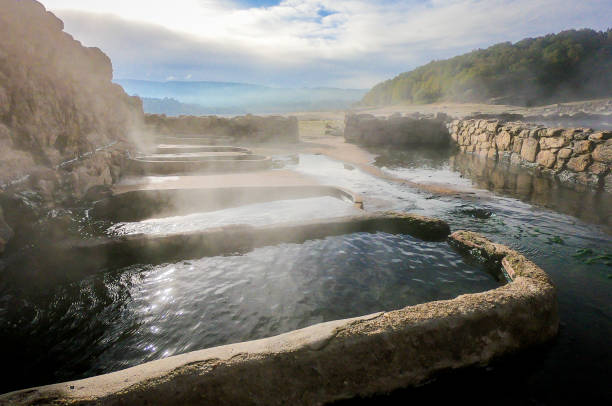 Natural Roman baths outdoors with hot steam and thermal water. stock photo
