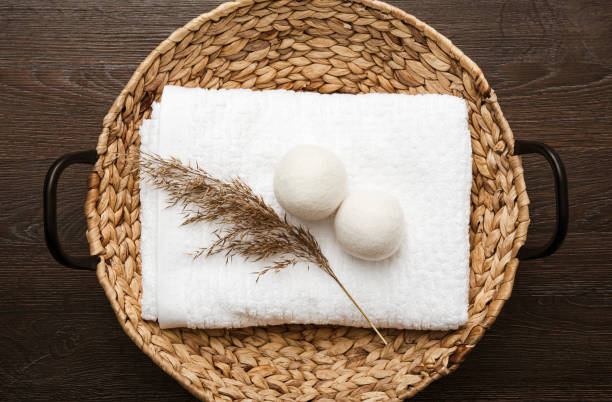 Natural wool dryer balls for more soft clothes while tumble drying in washing machine concept. Earthly tones, reed decoration. Discharge static electricity and shorten drying time, save energy. stock photo